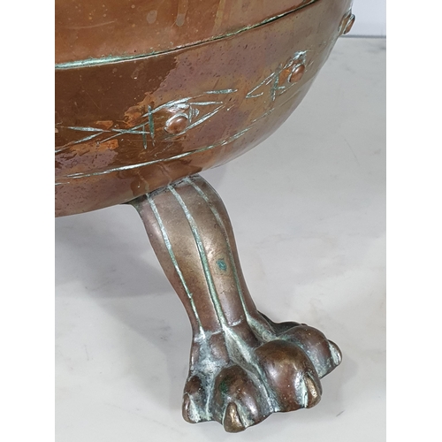 365 - An antique copper Log Cauldron with lion mask ring handles, raised on paw supports, 15