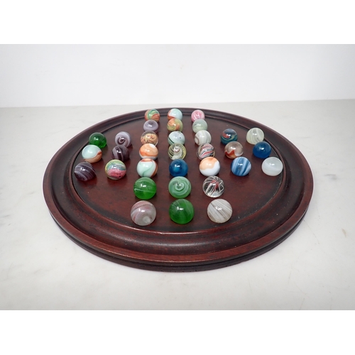 372 - A 19th Century mahogany circular Solitaire Board, 12in diam, and a collection of old coloured Marble... 