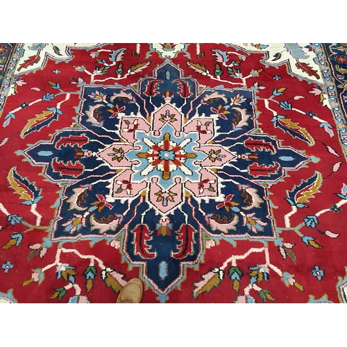 381 - A Persian Carpet with multiple borders, stylised floral designs with a central blue star medallion o... 