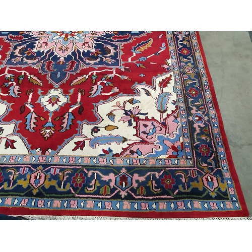 381 - A Persian Carpet with multiple borders, stylised floral designs with a central blue star medallion o... 