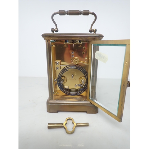 404 - A French brass cased Carriage Clock with white enamel circular dial, lever escapement, striking on c... 