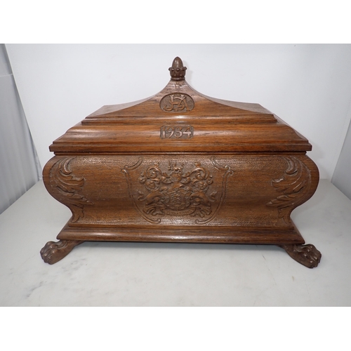 425 - A 20th Century oak Casket of sarcophagus shape, carved with coat of arms, initials JSA 1934, raised ... 