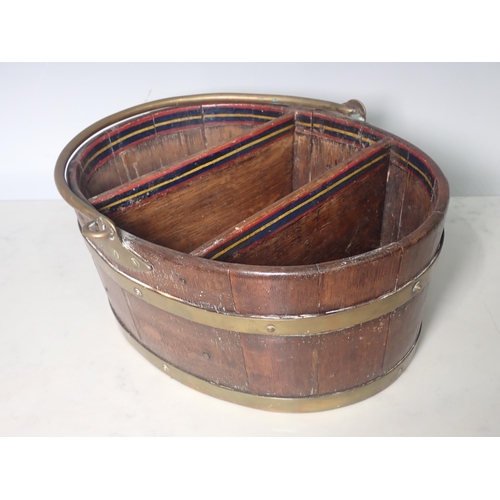 445 - An oak and brass bound Basket with brass swing handle of oval shape with two dividers and painted de... 