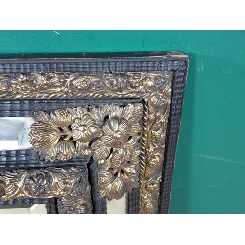 452 - A Dutch repoussé Wall Mirror with central bevelled plate surrounded by floral embossed brass and out... 