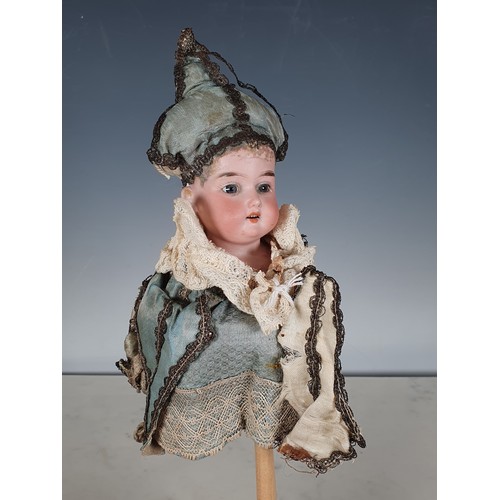 375 - A bisque head musical Marotte with working wooden whistle handle, the head with blue eyes, open mout... 