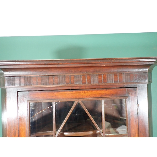 512 - A Georgian oak double Corner Cupboard with astragal glazed upper door enclosing shaped shelves above... 