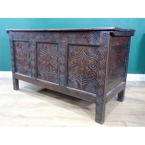 523 - An antique oak Coffer with moulded hinged cover above a three panelled carved front, 4ft 3in W