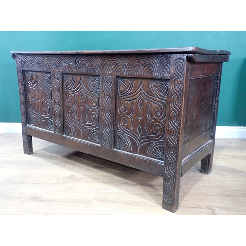 523 - An antique oak Coffer with moulded hinged cover above a three panelled carved front, 4ft 3in W