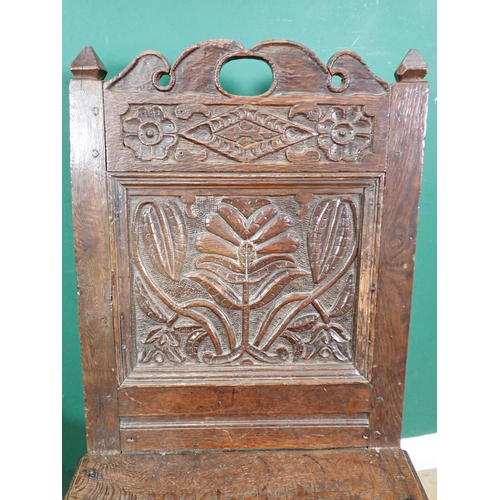 525 - A pair of 17th Century oak Hall Chairs with pierced shaped crests above foliate carved panel backs, ... 