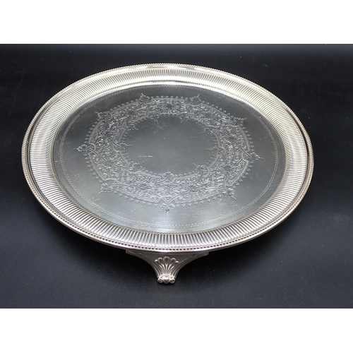 62 - A Victorian silver circular Salver with strapwork engraving and beaded rim on three bracket feet, Lo... 