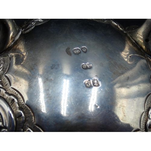 97 - A set of three William IV large silver Cauldron Salts with floral and scroll embossing, raised on pa... 