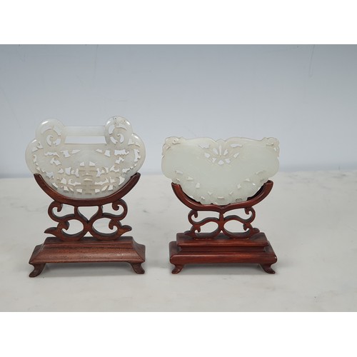 322 - Two 19th Century carved and pierced Jade pieces on carved hardwood stands, approx 3in x 2in