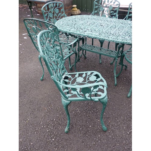 387 - A green painted metal Garden Table 4ft 7in W x 2ft 4in H and six Chairs with trailing rose back (one... 