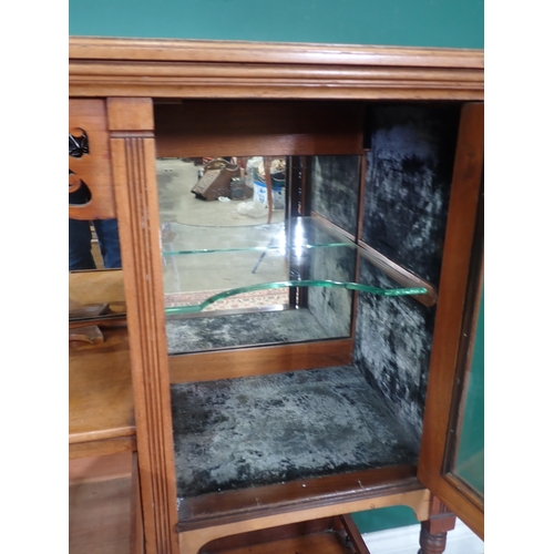 10 - A Sideboard with pair of glazed doors, carved frieze above open shelf, two small fitted drawers on t... 