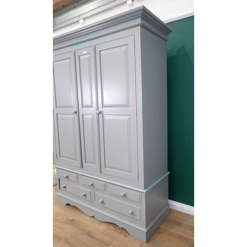 465 - A modern painted pine Wardrobe, the top section with pair of panelled doors, above the base fitted t... 