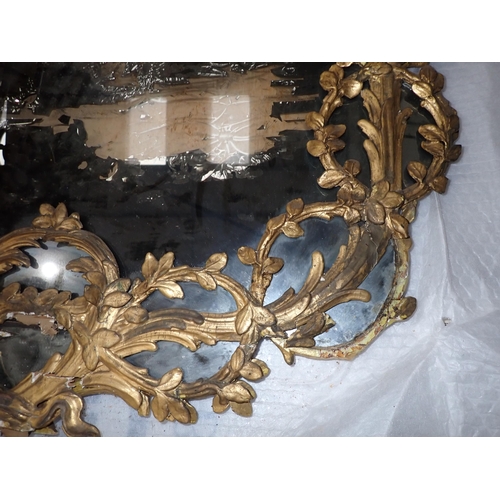 470 - An 18th Century giltwood framed Wall Mirror with circular leafage and pendant design, 4ft 3in x 2ft ... 