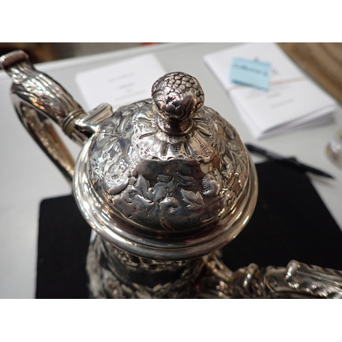 82 - A George IV silver Coffee Pot of pear shape with floral embossing, engraved crest, domed cover havin... 