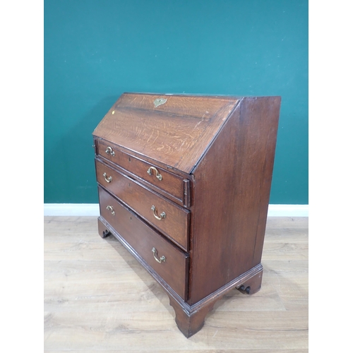 613 - A Georgian oak Bureau, the sloping front enclosing a fitted interior above three graduated drawers o... 