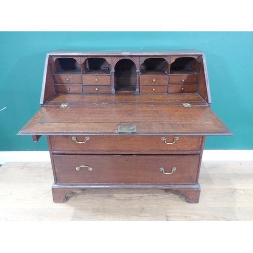 613 - A Georgian oak Bureau, the sloping front enclosing a fitted interior above three graduated drawers o... 