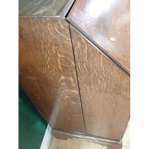 613 - A Georgian oak Bureau, the sloping front enclosing a fitted interior above three graduated drawers o... 