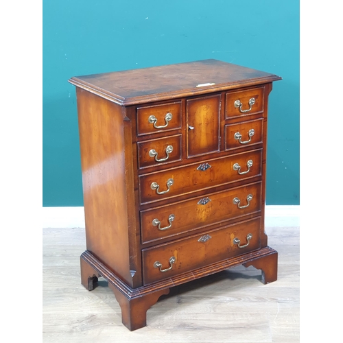 1 - A reproduction chest of three long and four short drawers with central hatch door to the top 2ft 9