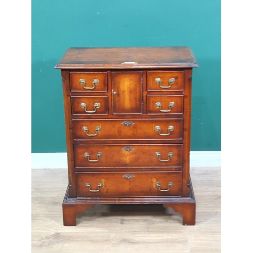 1 - A reproduction chest of three long and four short drawers with central hatch door to the top 2ft 9