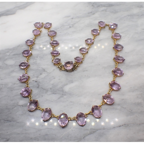 191 - An Amethyst Riviere Necklace claw-set graduated oval-cut stones and round stone on clasp in unmarked... 