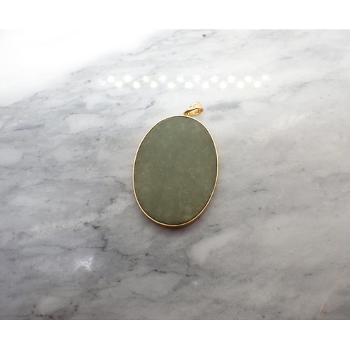 204 - A modern Jade Pendant in gold frame with applied Chinese character to front, stamped 18K, approx 35m... 