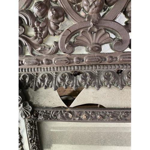 284 - A Continental repousse Wall Mirror with scrolled and shell surmount, 23in H A/F