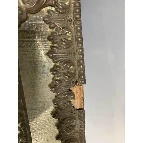 284 - A Continental repousse Wall Mirror with scrolled and shell surmount, 23in H A/F