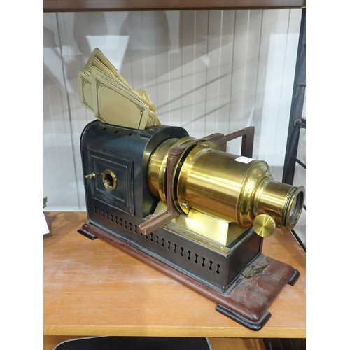 51 - A brass and japanned metal Magic Lantern on mahogany platform base, 17in; plus a quantity of reprodu... 