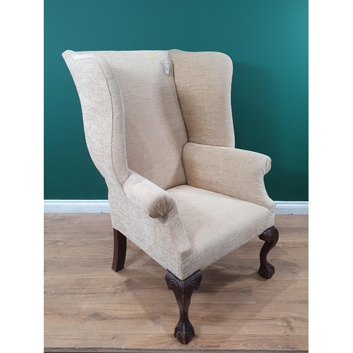 492 - A Georgian style wingback Armchair with carved cabriole front supports on ball and claw supports