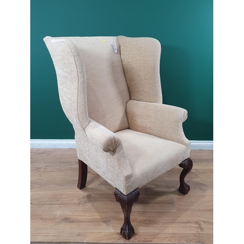 492 - A Georgian style wingback Armchair with carved cabriole front supports on ball and claw supports