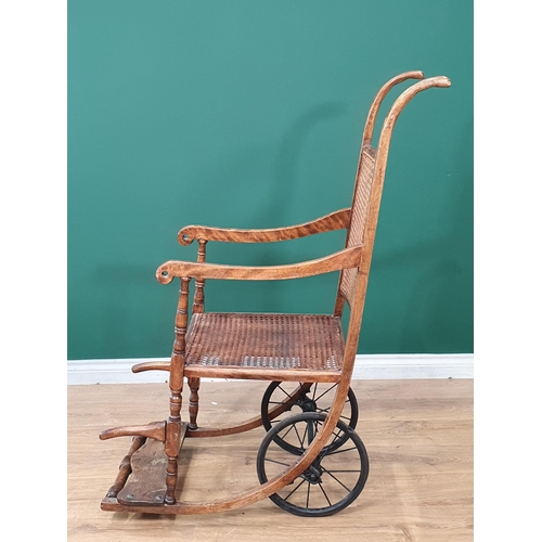 505 - An antique ash and cane Wheel Chair 4ft H x 1ft 7in W