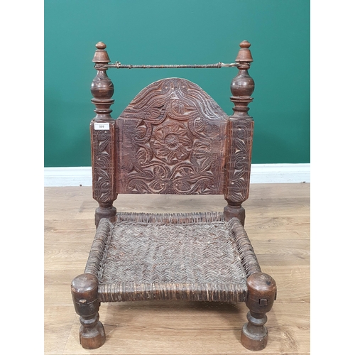 509 - An Indian carved Low pidha Chair with arched back, woven seat on turned supports