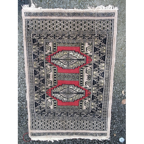 64 - Two small Persian style Rugs with stylised guls on a brown, blue and red ground, 3ft 2in x 2ft 2in