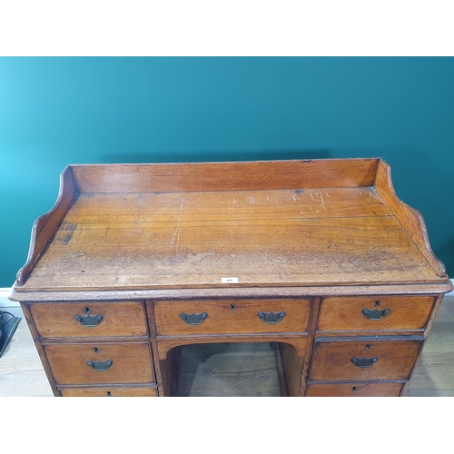 664 - An antique oak kneehole Desk with raised back fitted seven drawers on bun feet 4ft W x 3ft W