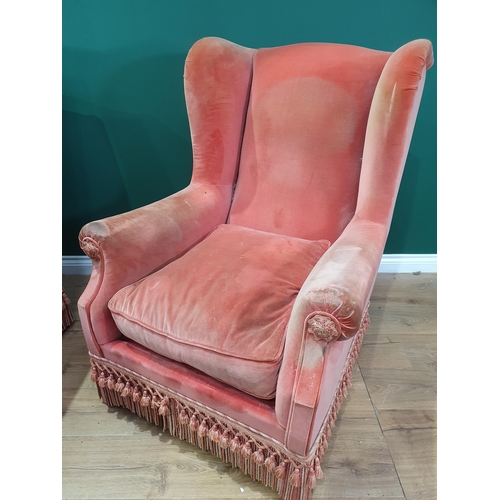 787 - A pair of pink upholstered winged Armchairs with tasselled fringe 3ft 6in H x 2ft 8in W