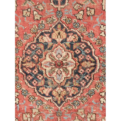 854 - A red ground Rug with floral multi-borders and a central floral motif, 6ft 1in x 4ft 3in