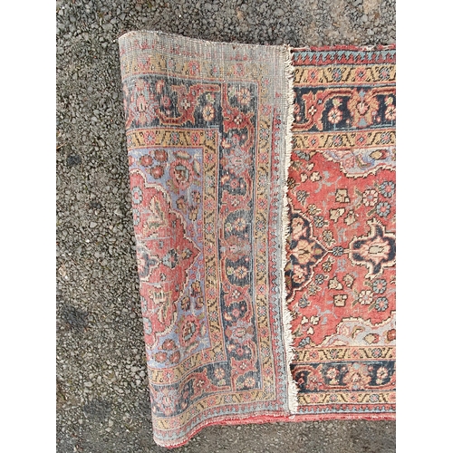 854 - A red ground Rug with floral multi-borders and a central floral motif, 6ft 1in x 4ft 3in