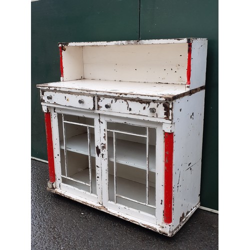 631 - A white painted glazed Cabinet with raised upper section above two drawers and two glazed panelled d... 