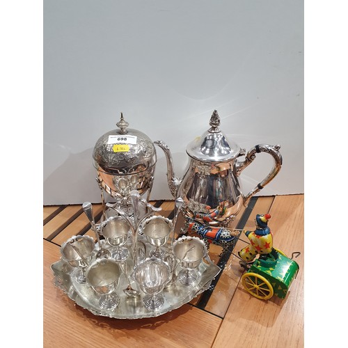 698 - A silver plated Coffee Pot, Samovar, a set of Egg Cups on stand and a clockwork Clown