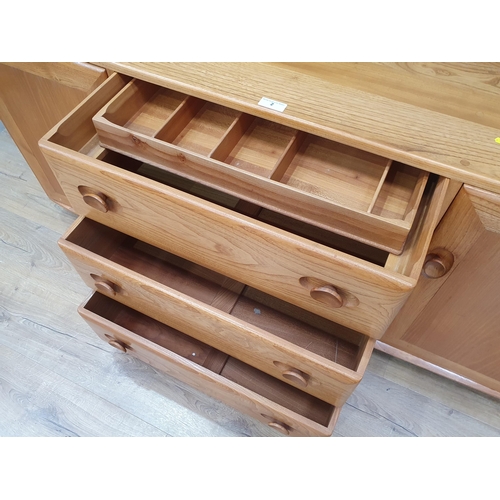 2 - An Ercol Sideboard fitted three drawers flanked by panelled cupboard doors, raised on castors, 5ft 2... 