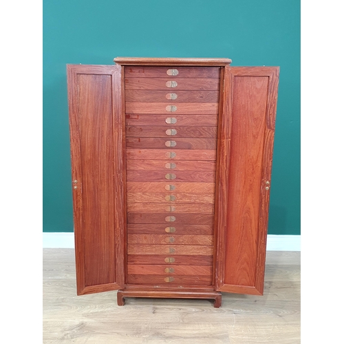 29 - A oriental hardwood Collectors Cabinet, the pair of panelled doors enclosing twenty glass lidded dra... 