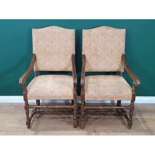 459 - A set of four beige floral upholstered oak Elbow Chairs on turned supports and stretchers.