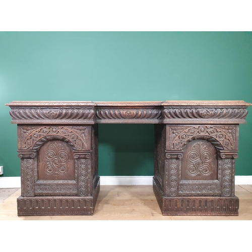 467 - A heavily carved oak Victorian Breakfront Pedestal Sideboard, the top fitted three drawers above pai... 