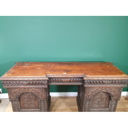 467 - A heavily carved oak Victorian Breakfront Pedestal Sideboard, the top fitted three drawers above pai... 