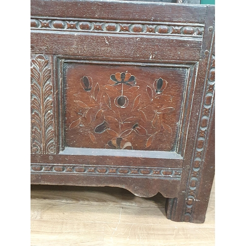 515 - A 17th Century oak and elm Coffer with two plank top, above carved and floral inlaid three panel fro... 