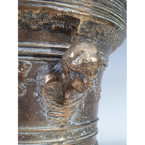 527 - A brass Pestle and Mortar with figurehead handles and mask and swag decorations, and a pair of brass... 