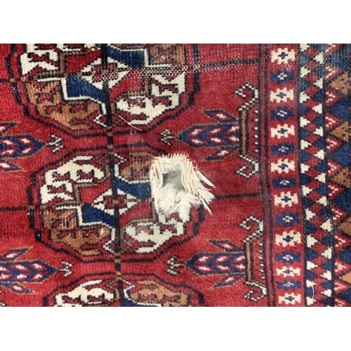 543 - A Pakistan Bokhara Rug with three rows of medallions on a red and maroon ground, 6ft x 4ft 6ft x 4ft... 